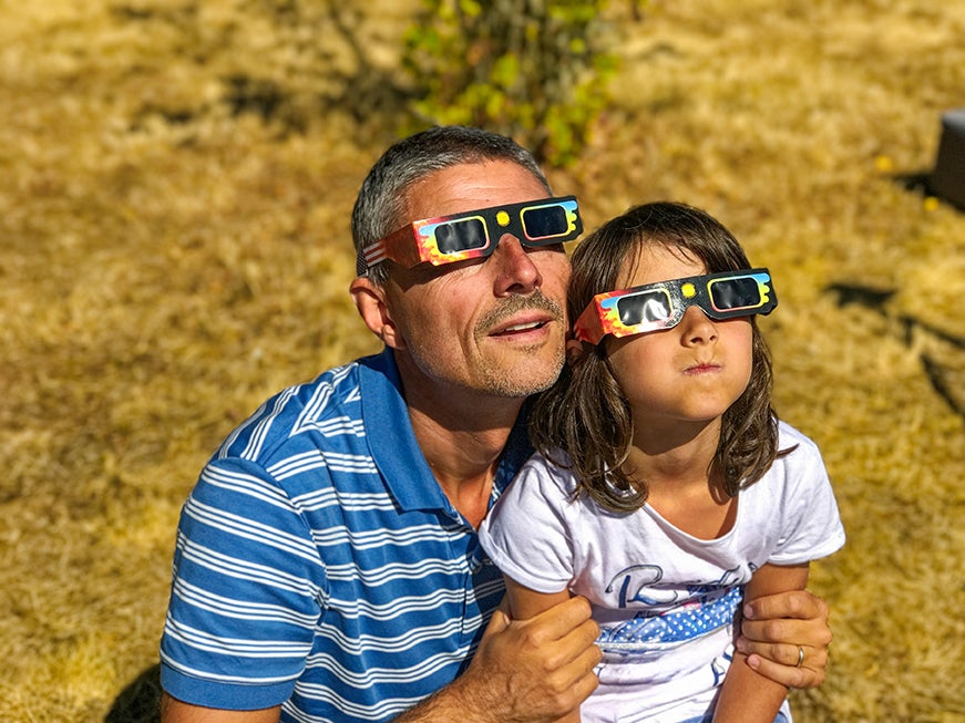 "Father and daughter wearing solar glasses"