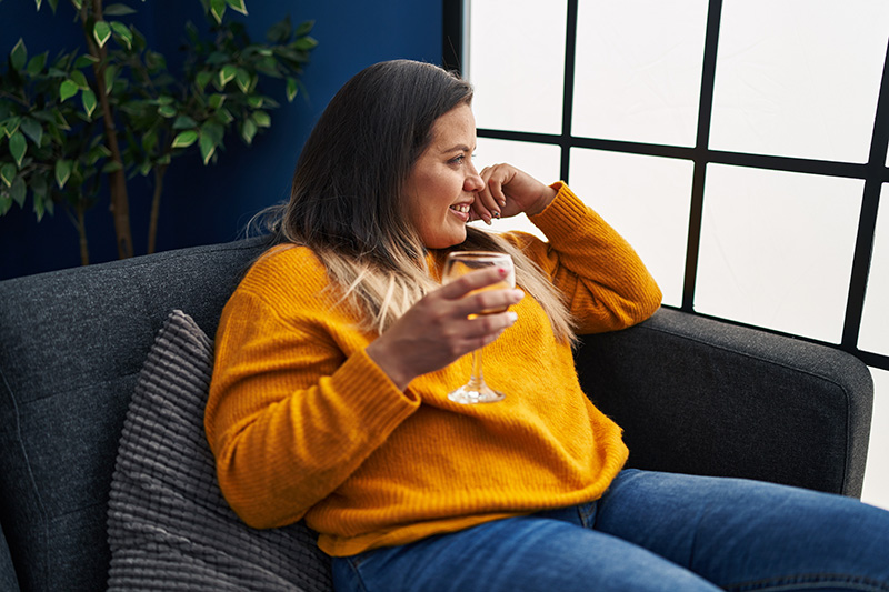 Woman with wine glass looking out of window
